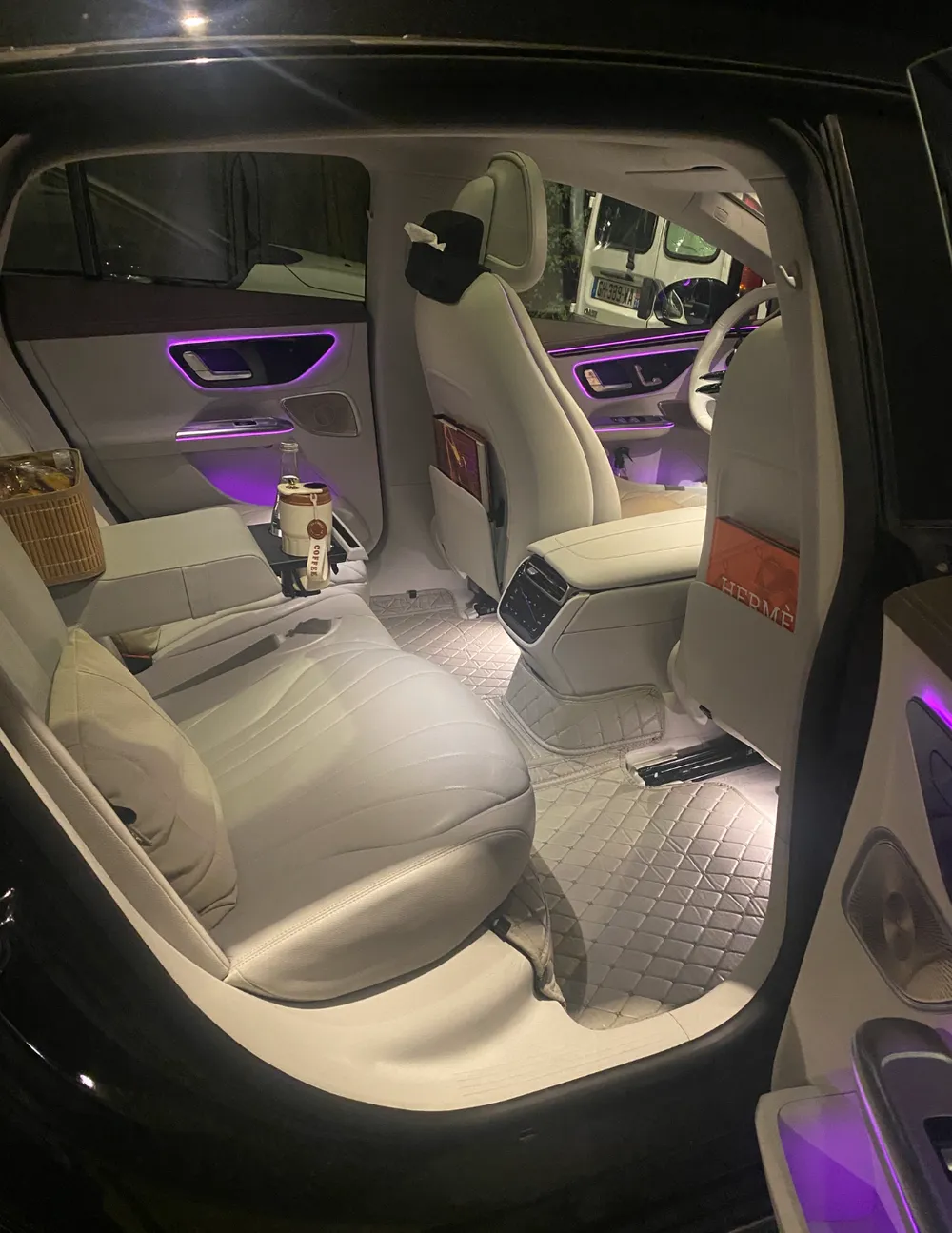 Autre vue de la banquette arrière de la Mercedes EQE de Toulouse VTC Pro — cuir clair, appuie-tête et toit panoramique